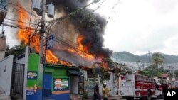 A building burns, set afire by protesters in Port-au-Prince, Haiti, Sept. 27, 2019. Thousands seeking to oust President Jovenel Moise attacked businesses and government buildings across Haiti, fed up with a lengthy shutdown of vital services.