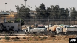 Truk-truk yang membawa bantuan kemanusiaan dari Mesir menunggu di wilayah Palestina di penyeberangan perbatasan Rafah di bagian selatan Jalur Gaza, 1 November 2023. (Foto: Mohammad Abed/AFP)
