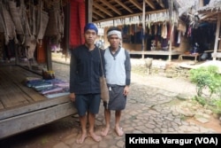 An Outer Baduy man, dressed in the traditional blue and black, and an Inner Baduy man, dressed in white and black.