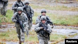 FILE - U.S. Army soldiers train during an exercise at the Adazi Training Area, Latvia, Oct. 20, 2010. The U.S. is deploying troops to Poland, the Baltic states and Romania as part of efforts to bolster regional security, officials say.