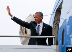 US President Barack Obama waves as he boards Air Force One during his departure from Tegel International Airport in Berlin, Nov. 18, 2016.