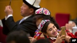 2016年3月8日，中国人大会议期间新疆代表在北京人民大会堂的用智能手机拍照。