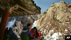 South Korean tourists look at the Diamond Mountain range in eastern North Korea near the demilitarized zone that divides the two Koreas.