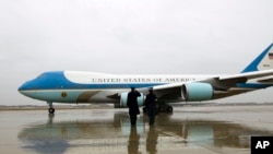 Personel Angkatan Udara AS memberi hormat saat pesawat Air Force One dengan Presiden Barack Obama di dalamnya bersiap lepas landas dari Pangkalan Angkatan Udara Andrews di Maryland (6/12). (AP/Jose Luis Magana)