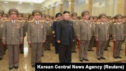 Pemimpin Korea Utara Kim Jong Un (tengah) saat mengunjungi makam kakeknya Kim Il Sung, dan ayahnya Kim Jong Il, di Istana Kumsusan (1/1).