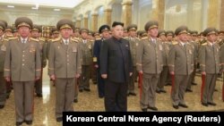 North Korean leader Kim Jong Un, center, pays his respects to his grandfather and North Korea founder, Kim Il Sung, and his father, Kim Jong Il, at Kumsusan Palace of the Sun, Jan. 1, 2015.