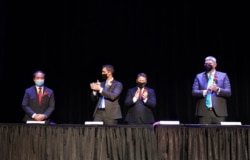 In this photo provided by Peg Shanahan, new Mayor Sokhary Chau, left, is applauded by councillors John Drinkwater, second from left, vice chair Erik Gitschier and Wayne Jenness during the Lowell City Council swearing-in ceremony, Monday, Jan. 3, 2022, in