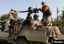 FILE - Houthi rebel fighters patrol a street in Sana'a, Yemen, Jan. 21, 2015.