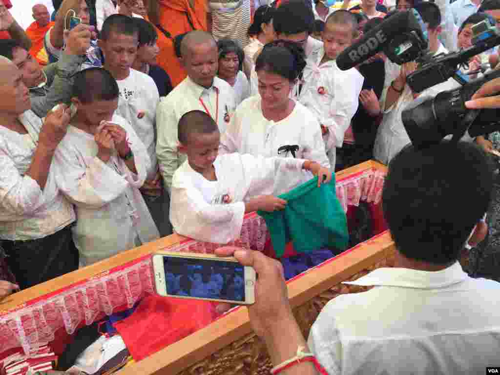 បងប្អូន សាច់ញ្ញាតិ និង​អ្នកចូលរួម​ក្នុង​ពិធីបុណ្យ​សព រៀប​បញ្ចុះ​សព​លោក​កែម ឡី ​នៅ​ស្រុក​កំណើត​របស់​លោក​ក្នុង​ឃុំ​លាយបូ ស្រុក​ត្រាំកក់ ខេត្ត​តាកែវ នា​ថ្ងៃ​ច័ន្ទ ទី២៥ ខែ​កក្កដា ឆ្នាំ​២០១៦។ (ហ៊ុល រស្មី/VOA)