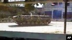 Foto yang diambil dari video amatir ini dirilis oleh Jaringan Berita Shaam, yang menunjukkan kendaraan lapis baja tentara Suriah yang masih berjaga di Idlib, Suriah (12/4).