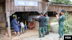 នគរបាលតាមដានការសម្ភាសន៍របស់ក្រុមការងារVOAជាមួយមេឃុំភ្នំព្រឹក នៅសាលាឃុំភ្នំព្រឹក ក្នុងស្រុកកំរៀង ខេត្តបាត់ដំបង កាលពីខែមីនា ឆ្នាំ២០១៨។ (អូន ឆេងប៉រ/VOA)