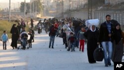 This Nov. 27, 2016, photo provided by the Rumaf, a Syrian Kurdish activist group, shows people fleeing rebel-held eastern neighborhoods of Aleppo into the Sheikh Maqsoud area that is controlled by Kurdish fighters.