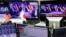 An employee of a foreign exchange trading company looks at monitors showing U.S. President elect Donald Trump speaking on TV news in Tokyo, Japan, Nov. 9, 2016. 