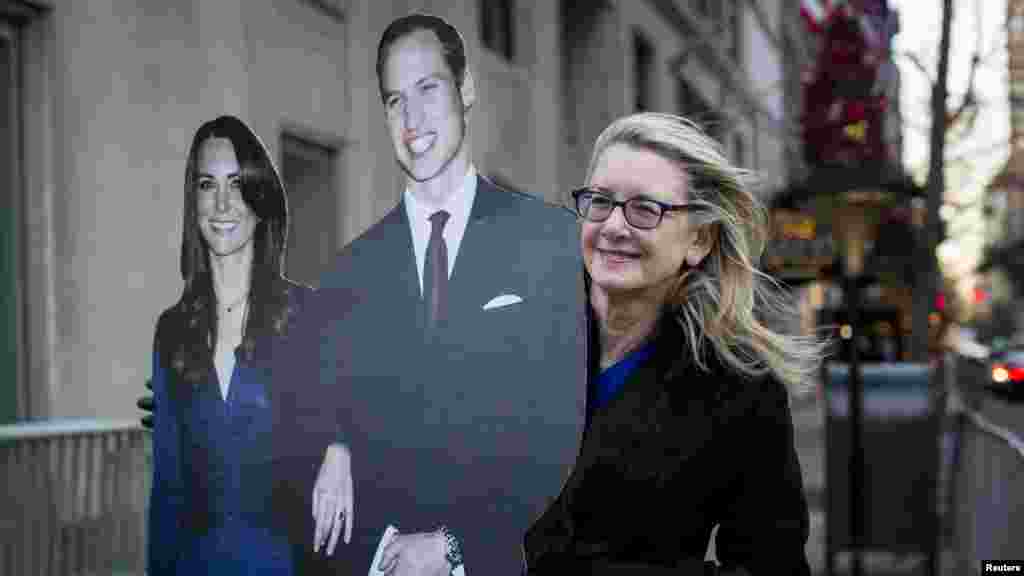 Un résident détient une effigie découpée du duc et de la duchesse de Cambridge, le prince William et sa femme, Catherine, devant l&#39;Hôtel Carlyle à New York, le 7 décembre 2014.