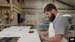 C.J. Haskett polishes the edge of a kitchen countertop cut from imported quartz slabs from China in the production facility at Marble Uniques in Tipton, Ind., May 3, 2019.