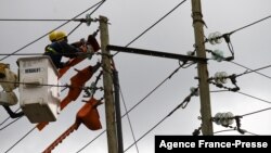 FILE - Kenya Power and Lighting Company (KPLC) live line experts relocate power lies to pave way for the construction of the Nairobi Expressway in Westlands, Nairobi, Sept. 24, 2020. 