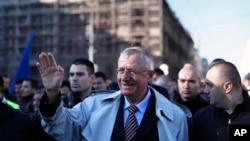 FILE - Serbian far right leader, Vojislav Seselj, center, waves to his supporters at a rally in Belgrade, Serbia, Nov. 15, 2014. 