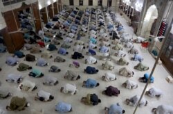 People attend evening prayers while maintaining a level of social distancing to help avoid the spread of the coronavirus, at a mosque in Karachi, Pakistan, April 19, 2020.