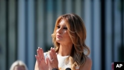 First Lady Melania Trump visits an exhibit of artwork by young Americans in celebration of the 100th anniversary of the 19th amendment which afforded the vote to women, at the White House in Washington, Aug. 24, 2020. 
