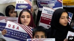 Refije Afghan kenbe pannkat pandan yon rankont pou diskite sou sityasyon yo apre Prezidan Donald Trump pran yon poz ak pwogram refije yo, 24 Janvye 2025. 