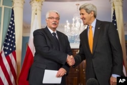 Polish Foreign Minister Witold Waszczykowski shakes hands with Secretary of State John Kerry prior to their meeting at the State Department in Washington, Feb. 17, 2016.