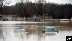 Two cars are submerged in floodwater in a park in Kimmswick, Mo., Dec. 28, 2015.