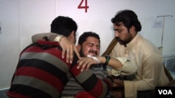 Tasbeeh Ullah, a Bacha Khan University student, receives help in a Pakistani hospital. He’d suffered broken bones after jumping from a campus rooftop to avoid a gunman firing at him in the Jan. 20 attack.