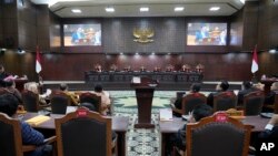 Hakim membuka sidang pertama gugatan pilpres 2024 yang diajukan oleh capres Ganjar Pranowo dan Mahfud MD, di Mahkamah Konstitusi, Jakarta, Rabu, 27 Maret 2024. (Foto: Achmad Ibrahim/AP Photo)