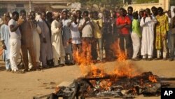 Wasu mutane ke kallon irin barnar da 'yan Boko Haram ke yi