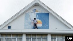 រូបឯកសារ៖ អ្នកគាំទ្រគណបក្សសង្គ្រោះជាតិម្នាក់លាបថ្នាំពី​លើ​ស្លាកសញ្ញាគណបក្សនេះនៅឯទីស្នាក់ការគណបក្សក្នុងរាជធានីភ្នំពេញ ថ្ងៃទី១៨ ខែវិច្ឆិកា ឆ្នាំ២០១៧។ 