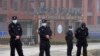 Security personnel gather near the entrance of the Wuhan Institute of Virology during a visit by the World Health Organization team in Wuhan in China's Hubei province on Wednesday, Feb. 3, 2021. 
