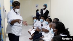 FILE - A health worker talks to colleagues as they prepare to receive a coronavirus vaccine at the Kenyatta National Hospital in Nairobi, Kenya, March 5, 2021. 