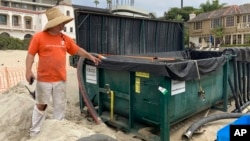 Marine scientist Robert Mooney shows a tank that some of an invasive algae was being pumped into from the harbor in Newport Beach, Calif., Wednesday, July 7, 2021.
