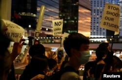 People hold placards during a protest following a day of violence over a proposed extradition bill, near the Legislative Council building in Hong Kong, June 13, 2019.