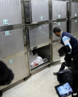 A relative looks at the body of a woman who was shot and killed by Israeli troops during a protest at the Gaza Strip's border with Israel, at the morgue of Shifa hospital in Gaza City, Friday, Jan. 11, 2019.