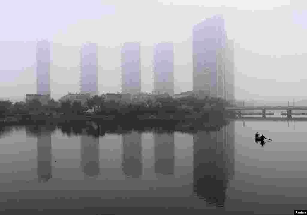 A man rows a boat on a river during a hazy morning in Shaoxing, Zhejiang province, June 16, 2013.&nbsp;