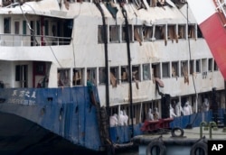 FILE - In this June 7, 2015 photo, rescuers search for passengers' belongings on the raised capsized ship Eastern Star on the Yangtze River in Jianli county of southern China’s Hubei province.