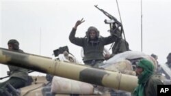 On this image taken during an organized trip by the Libyan authorities for a small group of journalists, Libyan soldiers loyal to Moammar Gadhafi's forces are seen on the western entrance of the city of Ajdabiya, Libya, Wednesday, March 16, 2011.