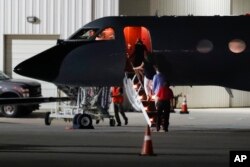Visitors and medical personnel enter a transport plane carrying Otto Warmbier, before he is transferred to an ambulance at Lunken regional airport, June 13, 2017, in Cincinnati, Ohio.