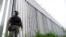 FILE - A policeman patrols alongside a steel wall at Evros River, near the village of Poros, at the Greek -Turkish border, Greece, May 21, 2021.