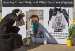 Chinese students hold a memorial for the late Dr. Li Wenliang - who was a whistleblower of COVID-19, that originated in Wuhan, China - outside the UCLA campus in Westwood, Calif. on Feb. 15, 2020.