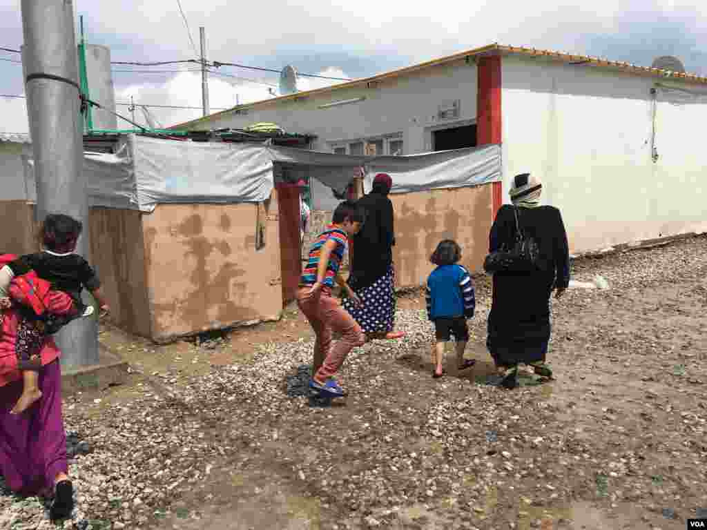 Small Iraqi boy avoiding puddles in a camp for people fleeing IS outside Makhmour, Iraq, April 11, 2016. (S. Behn/VOA)
