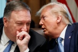 Secretary of State Mike Pompeo, left, and President Donald Trump whisper during a Cabinet meeting in the Cabinet Room of the White House, July 16, 2019, in Washington.