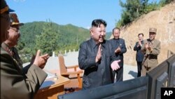 Les images diffusées par KRT montrent le leader nord-coréen Kim Jung Un applaudissant après le tir d’essai du missile balistique intercontinental Hwasong-14, 14 juillet 2017.
