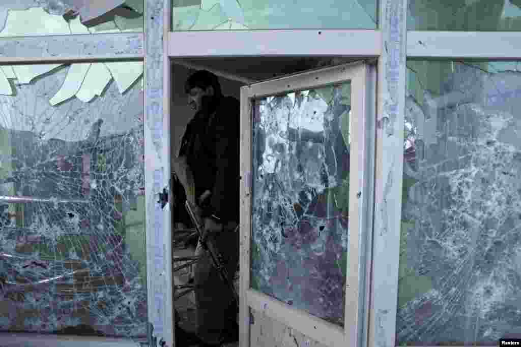 An Afghan policeman inspects a building used by insurgents after an operation near the Indian consulate in Mazar-i-Sharif. Afghan special forces killed a group of insurgents holed up in a house in the northern city of Mazar-i-Sharif, bringing to an end a 24-hour siege following the insurgents&#39; attack on the nearby Indian consulate.