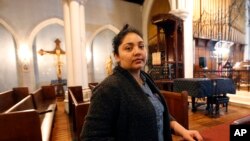 FILE - Amanda Morales seeks refuge in the sanctuary of the Holyrood Episcopal Church, northern Manhattan, Oct. 26, 2017.