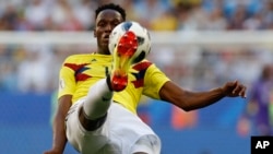 Colombia's Yerry Mina kicks during a match with Senegal in Samara, Russia, June 28. Colombia's team jersey goes for bold color. (AP)