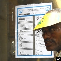 Before voters cast their ballots, election officials explain how to mark the ballot. Each symbol represents a different party, Addis Ababa, 23 May 2010