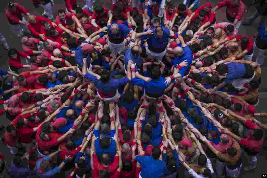 Para anggota kelompok Castellers &quot;Vila de Gracia&quot; mulai membentuk menara manusia yang disebut &quot;castell&quot; di lingkungan Barcelona Gracia, di Catalonia, Spanyol.