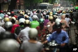 n this photo taken Monday, May 21, 2012, motorcyclists drive in rush hour on La Thanh street which is one of the worst traffic jam roads, in Hanoi, Vietnam.